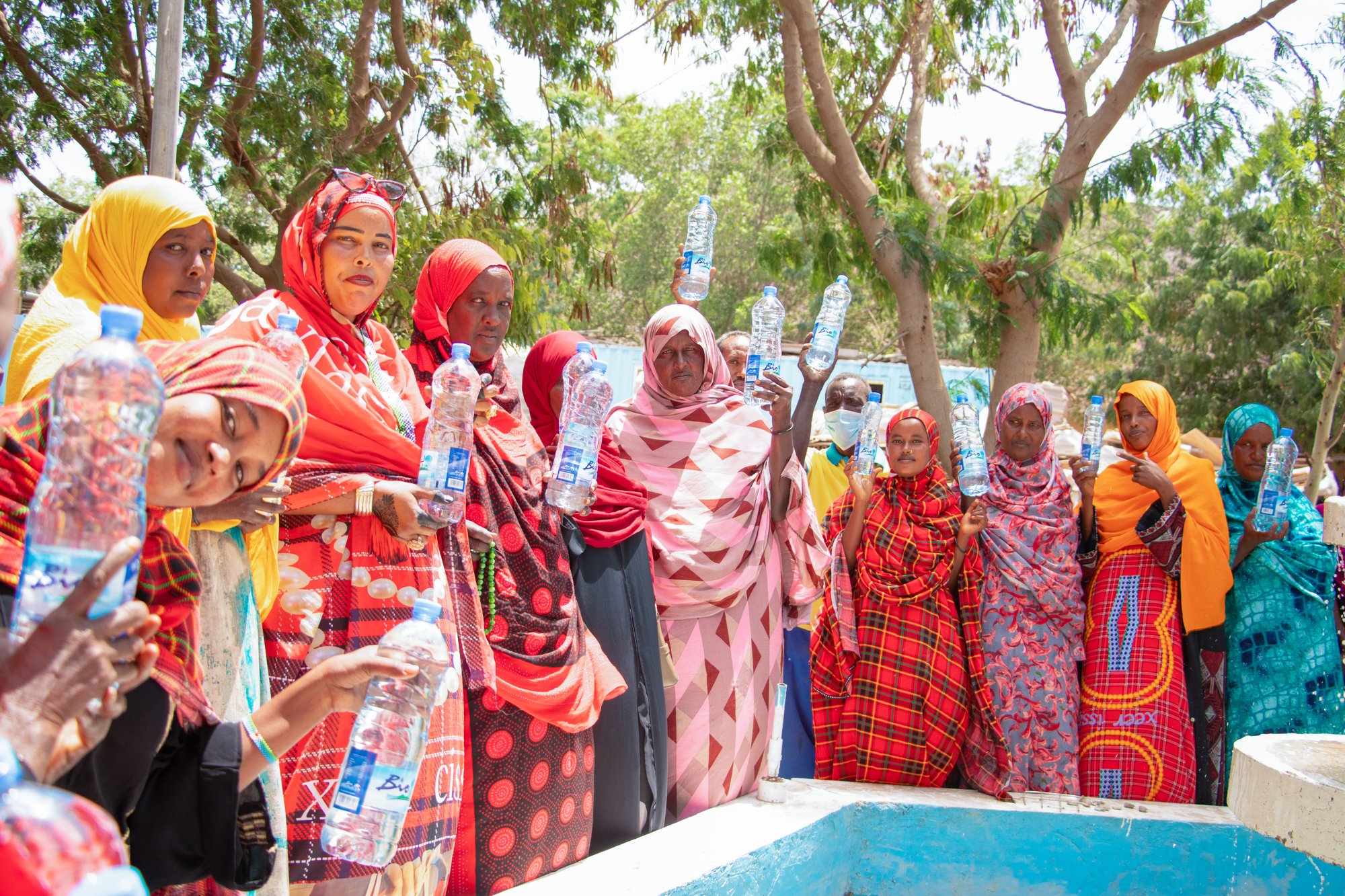 Un groupe de femmes de la communauté tenant des bouteilles d'eau Bio